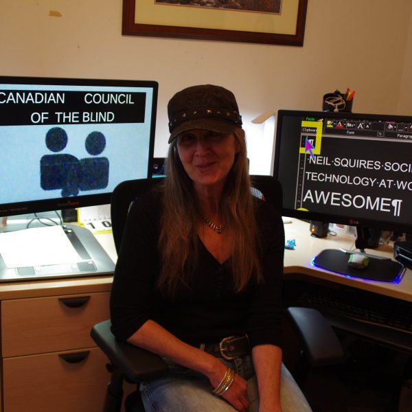 Girl sitting in front of two computers