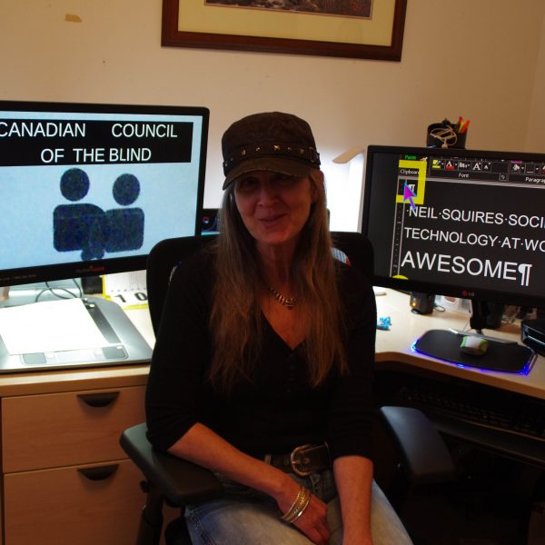 Girl sitting in front of two computers