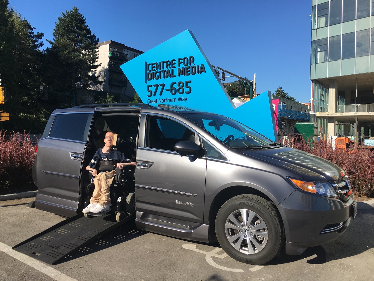 David emerging from his modified van outside his workplace