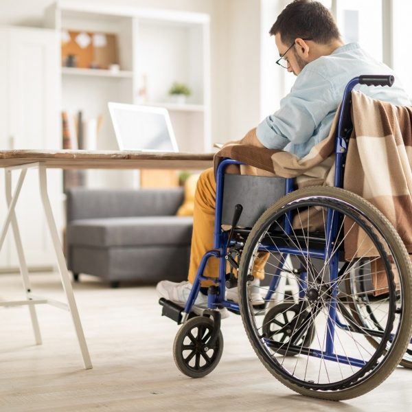 Man seated in wheelchair, writing