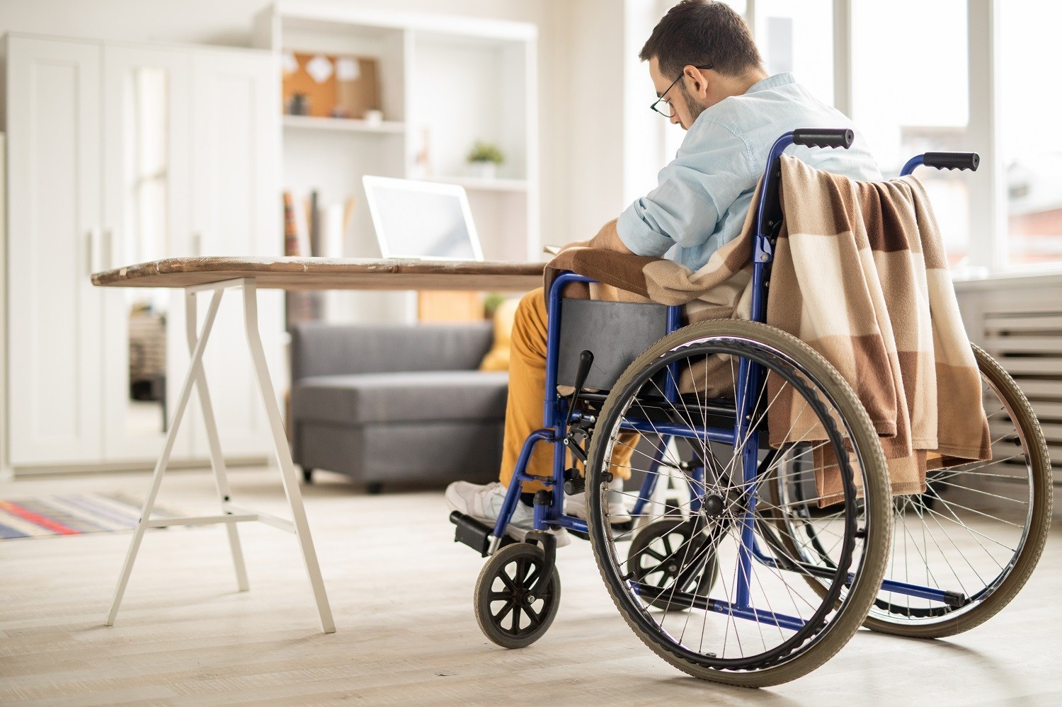 Man seated in wheelchair, writing