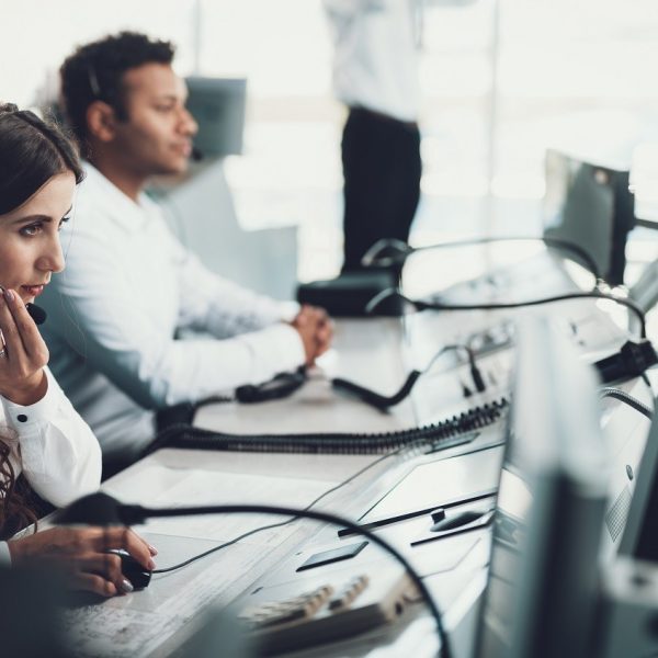 Two persons with headsets at a computer