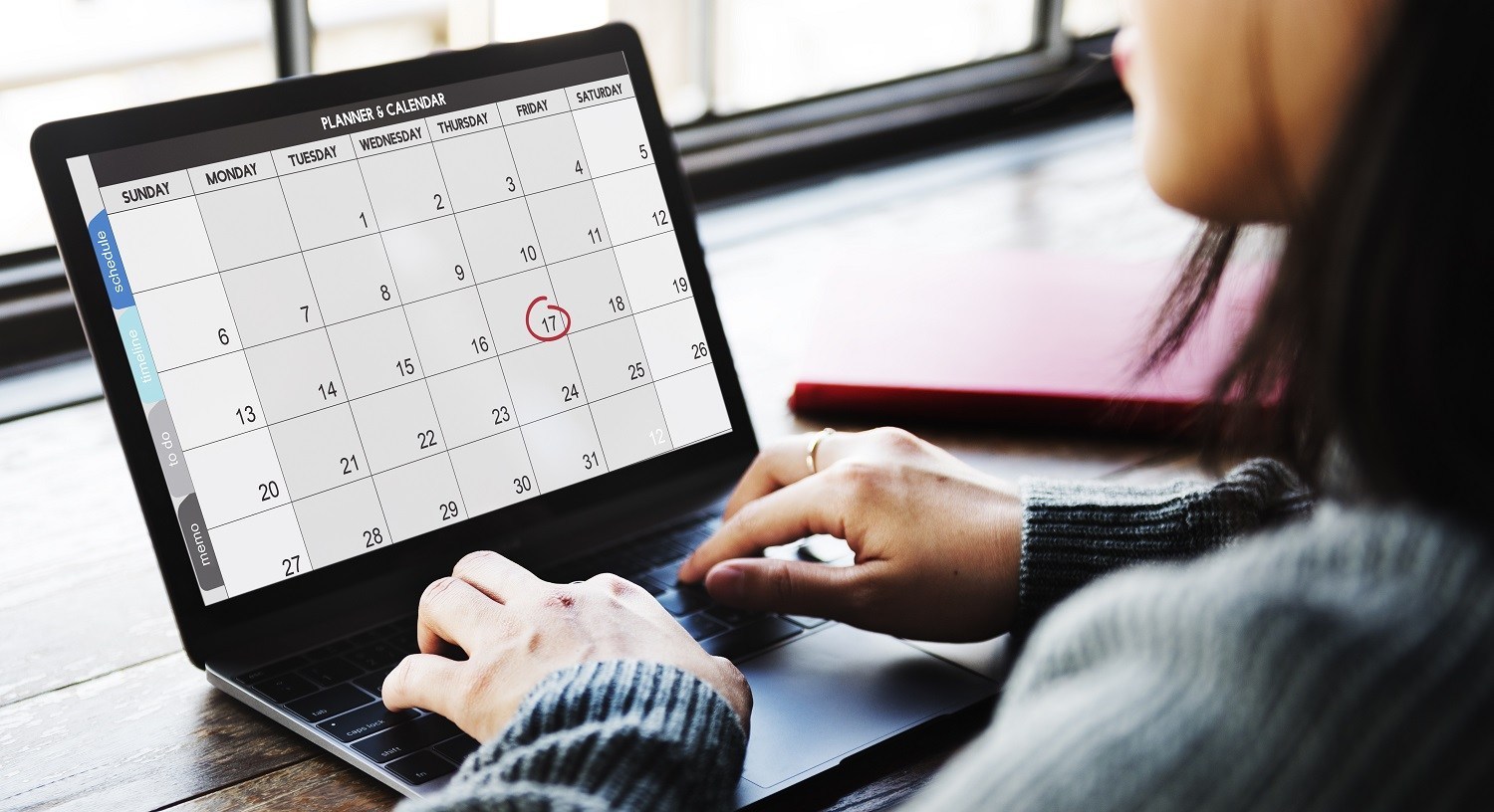 A woman using a calendar on her laptop