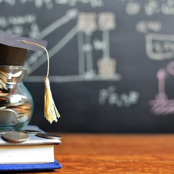 A small jar filled with coins, with a graduate cap atop it