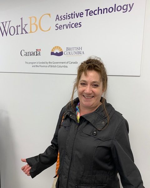 Karen in front of a WorkBC Assistive Technology Services sign