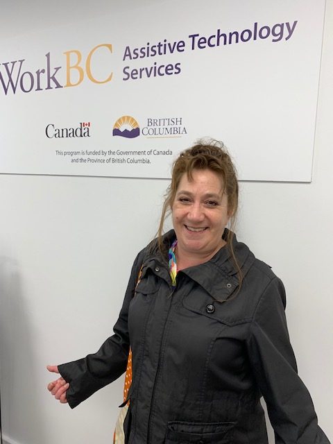 Karen in front of a WorkBC Assistive Technology Services sign