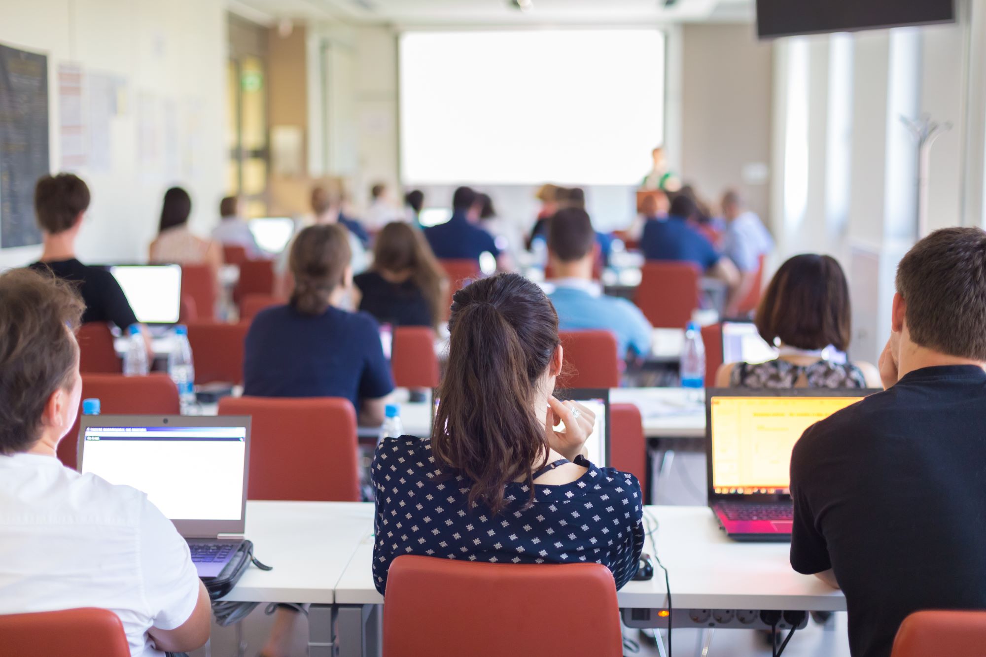 a classroom setting with students listening to a presentation