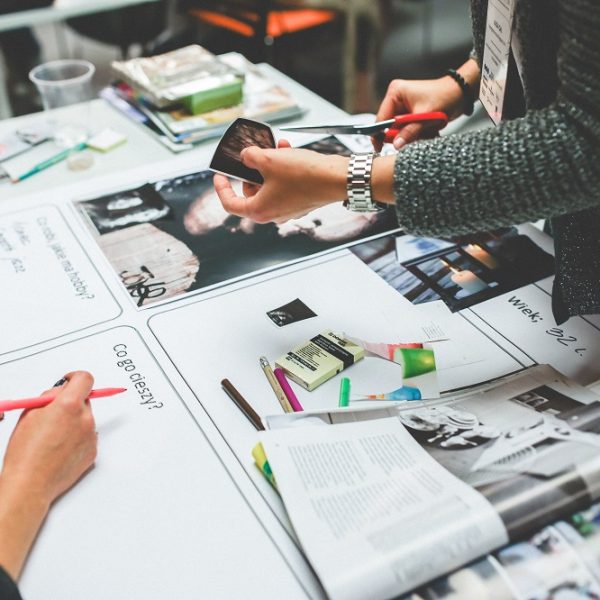 close-up of hands working on design items at a table