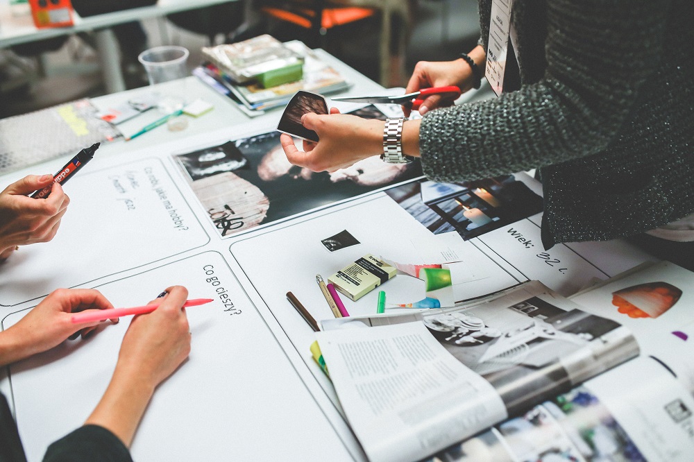 close-up of hands working on design items at a table