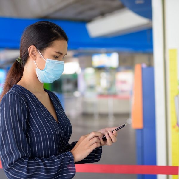Woman wearing a mask, using her phone