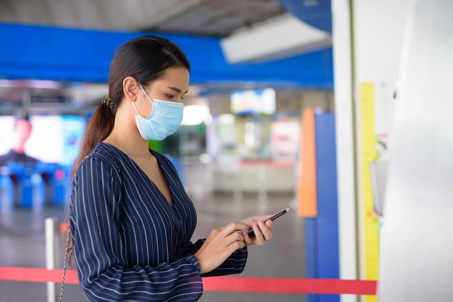 Woman wearing a mask, using her phone