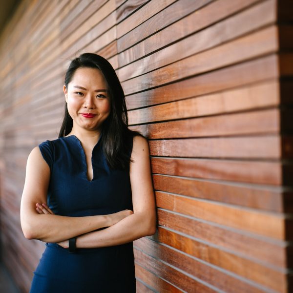 woman standing against a wall, smiling