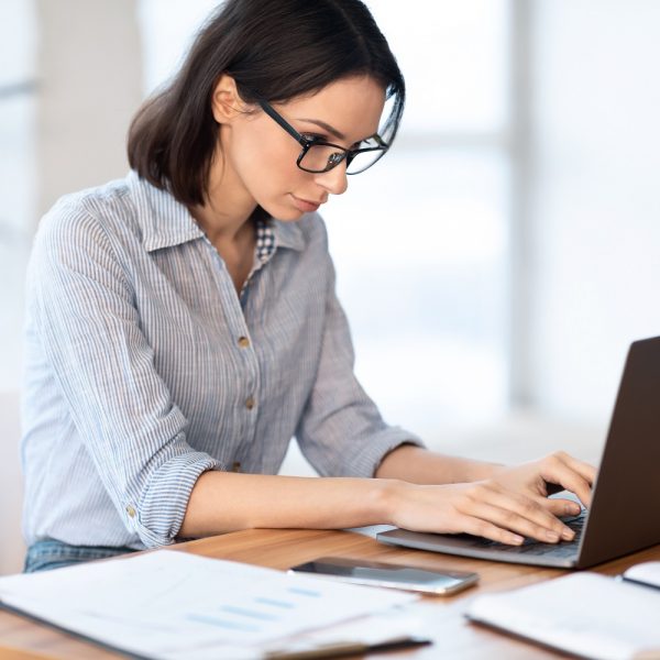 woman typing on her laptop at her desk