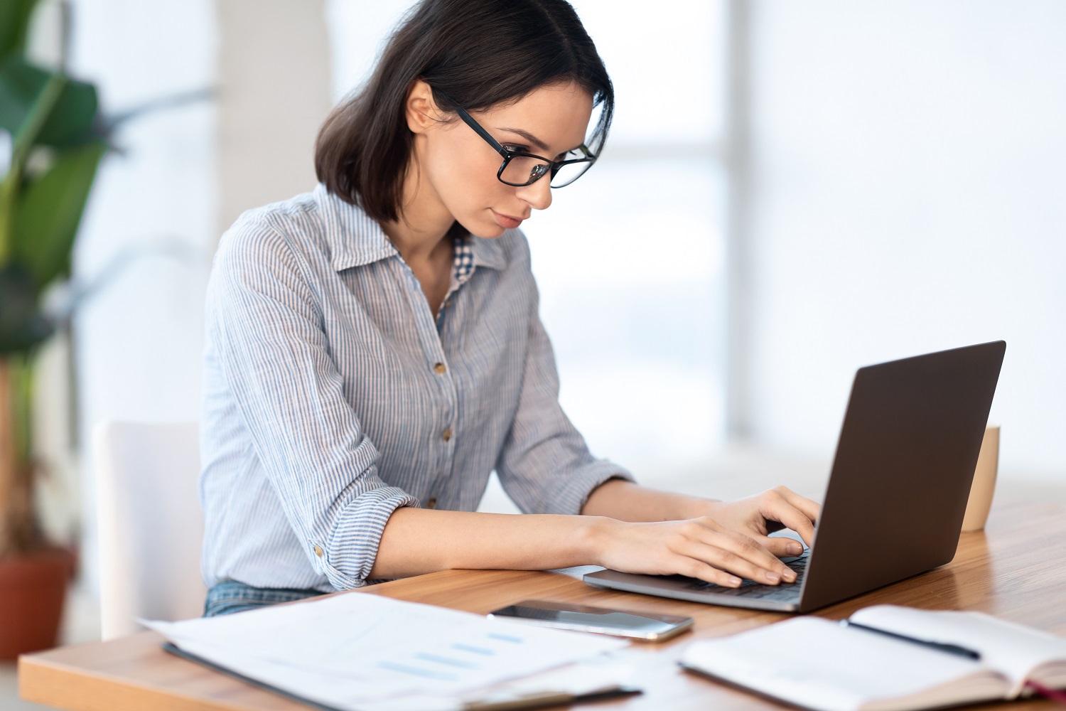 woman typing on her laptop at her desk