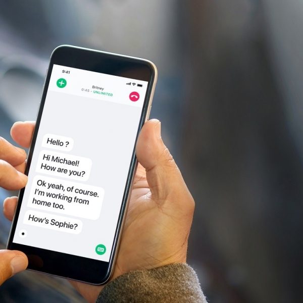 Close-up of person's hands using a smartphone, with a conversation transcript on the screen