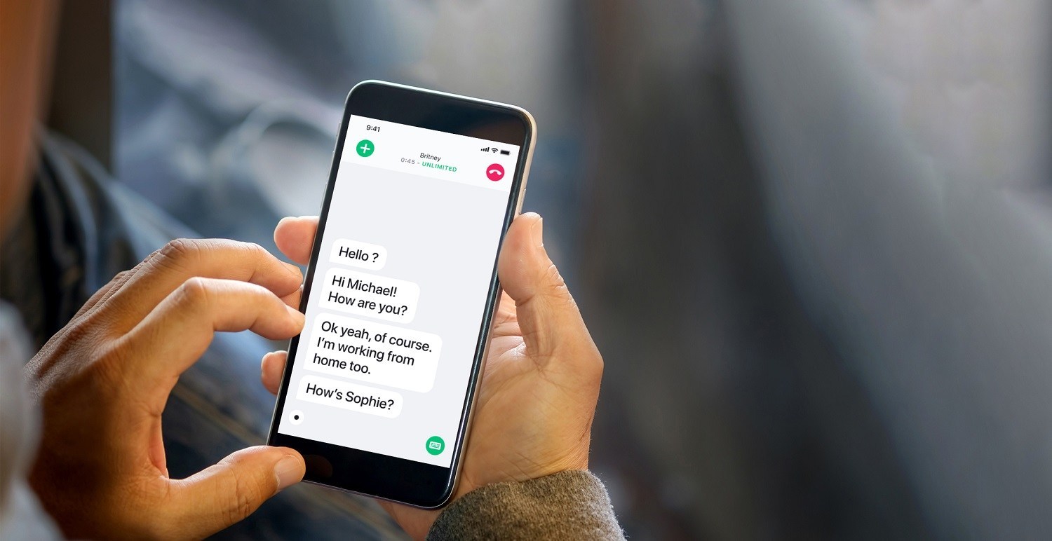 Close-up of person's hands using a smartphone, with a conversation transcript on the screen