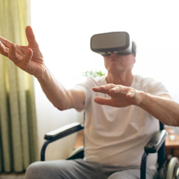 man seated in a wheelchair, using a virtual reality set