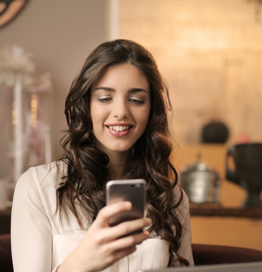 A woman using her phone, smiling
