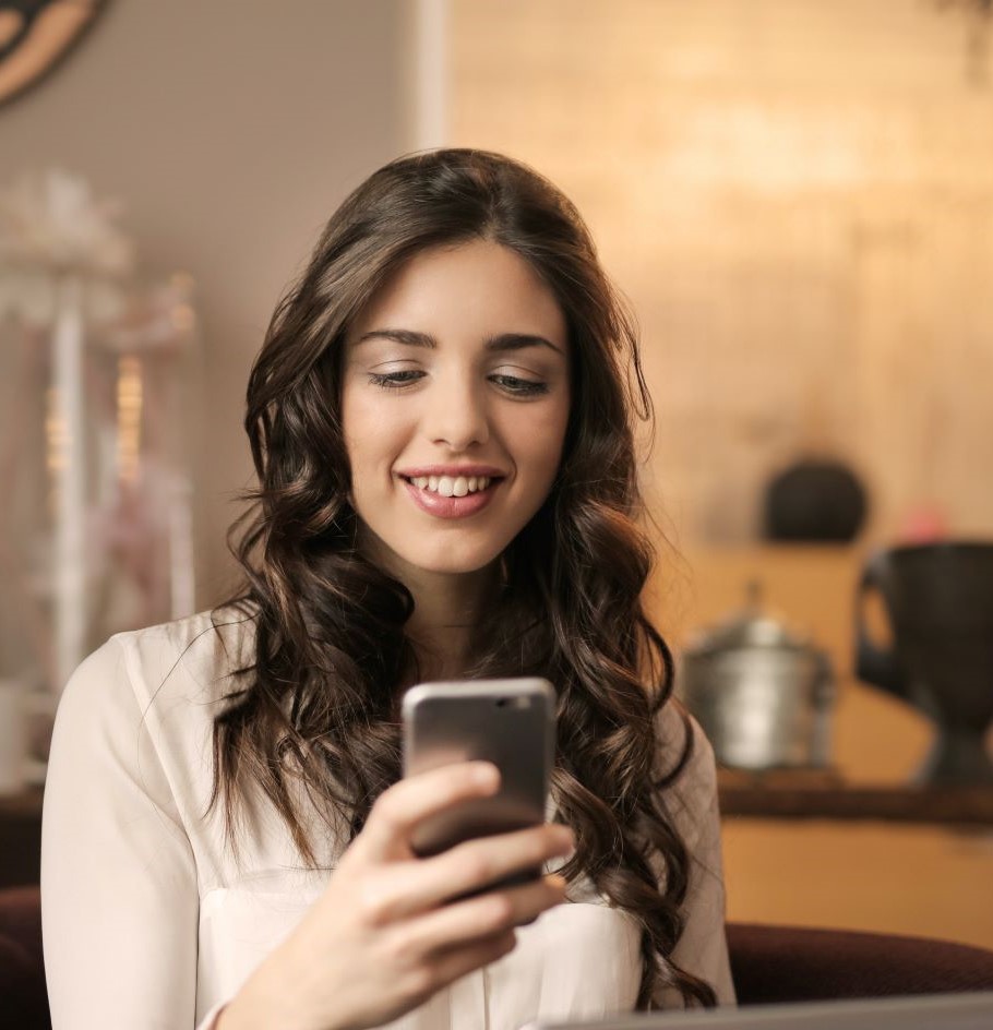A woman using her phone, smiling