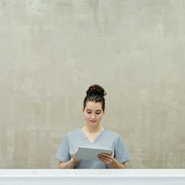 stock image of a woman using a tablet while standing in a hallway