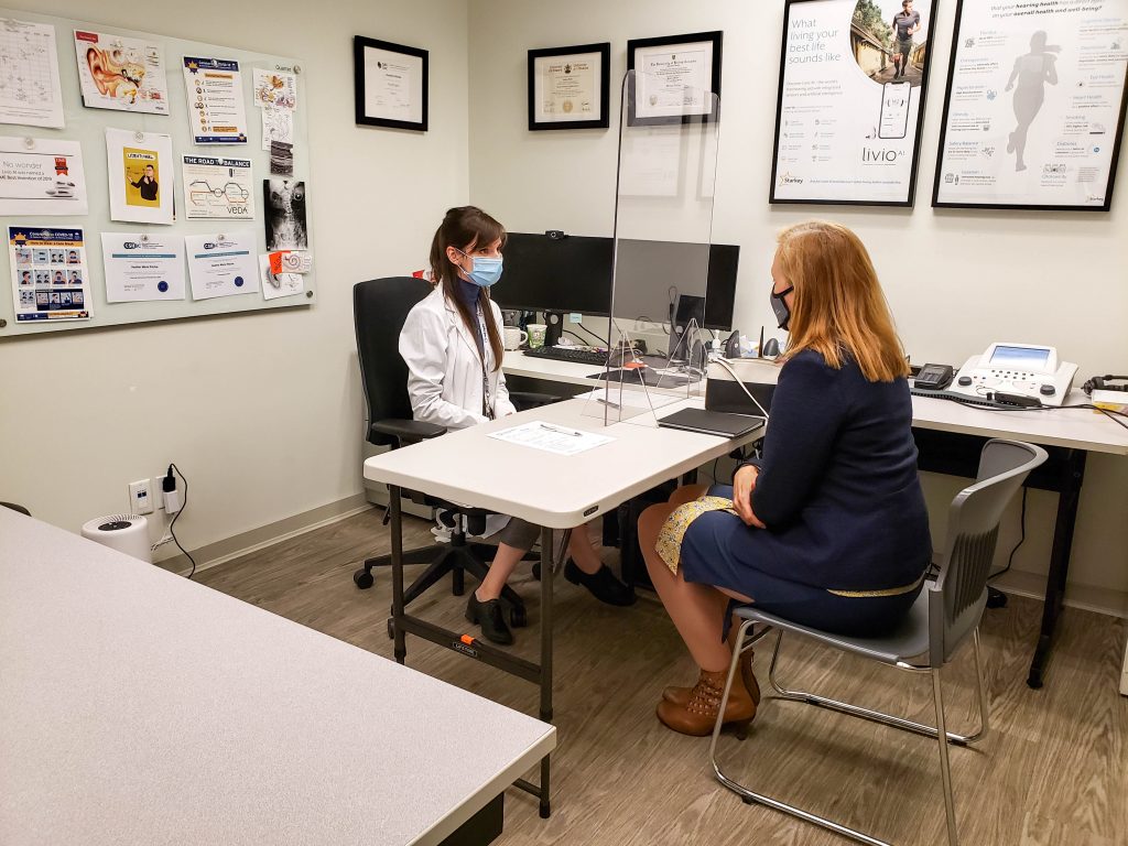 Brenda Bailey seated across from our Registered Audiologist, Heather