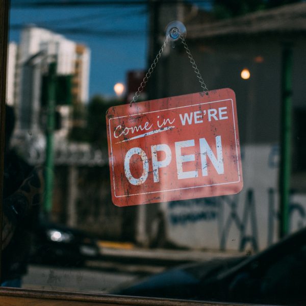 A storefront with the sign "Come in, we're open"