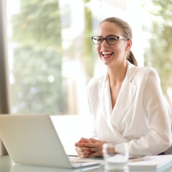 a woman smiling while working on her laptop