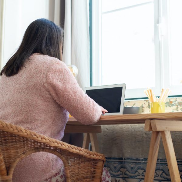 a woman working on her laptop at her home office