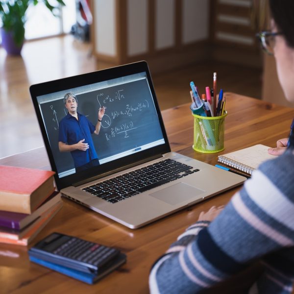 a woman watches a math lesson on her laptop