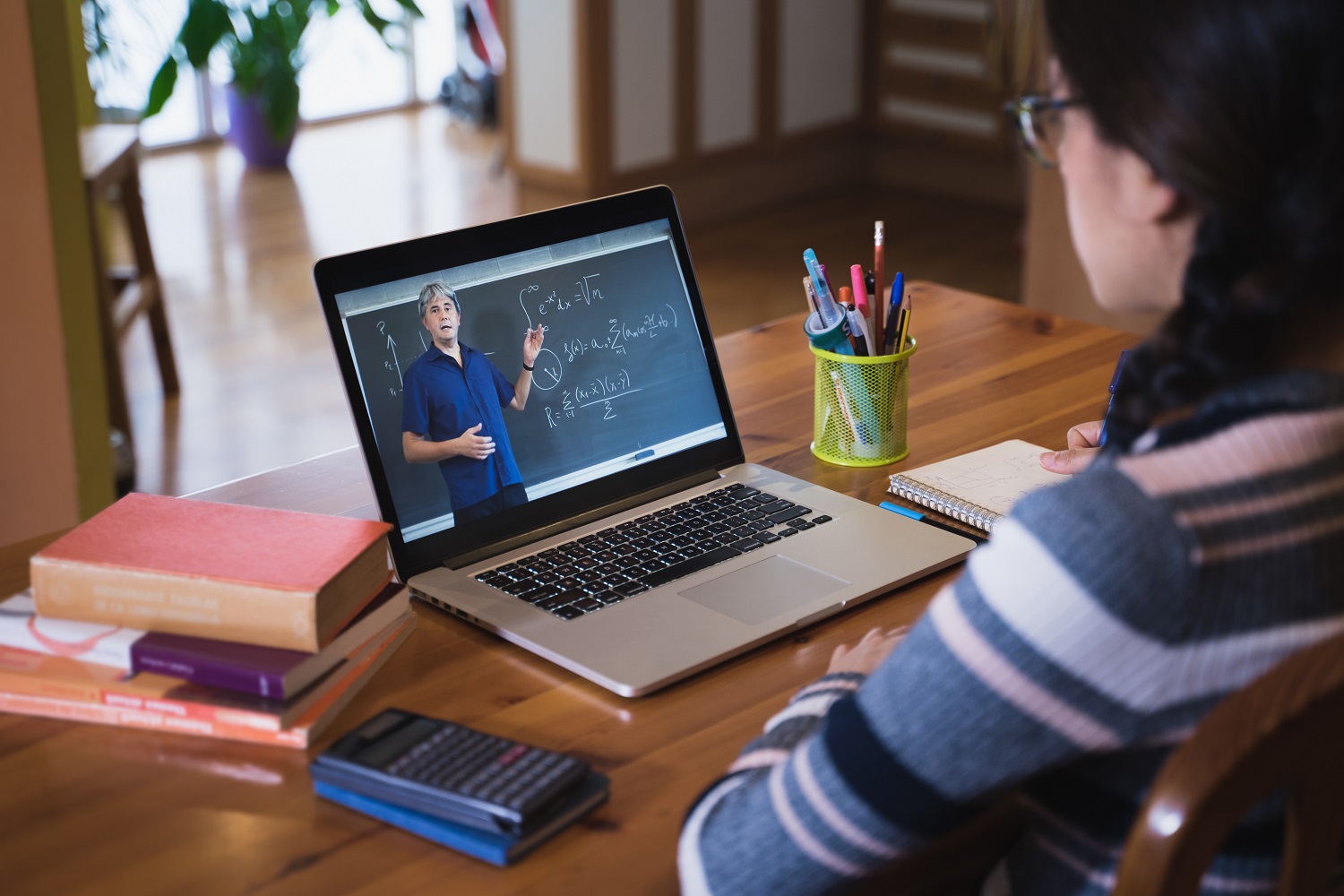 a woman watches a math lesson on her laptop