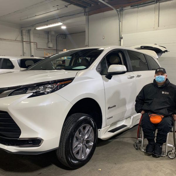 Bradley sits in a wheelchair next to his new van