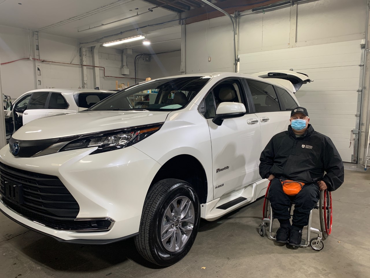 Bradley sits in a wheelchair next to his new van