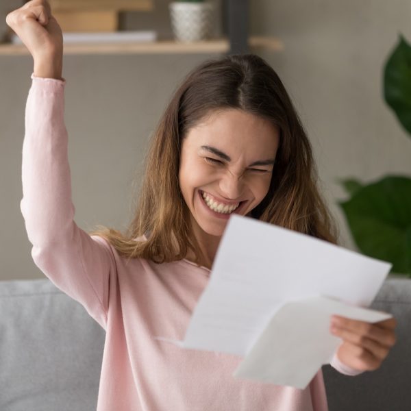 a woman celebrating news that she received in the mail