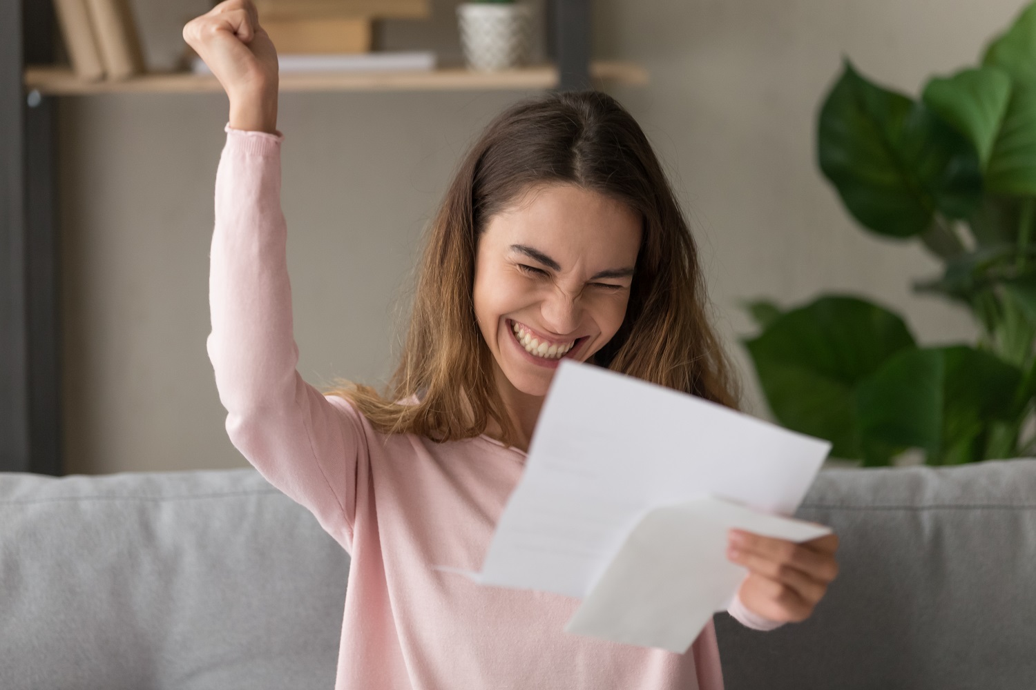 a woman celebrating news that she received in the mail