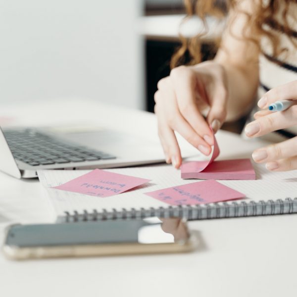 a woman writing on sticky notes