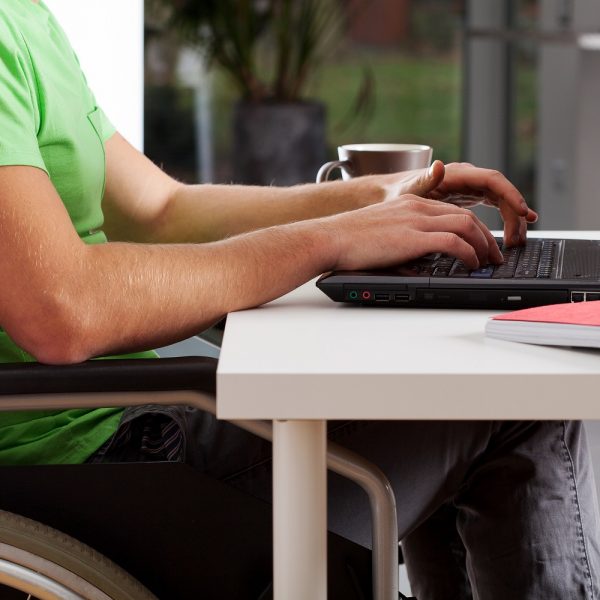 a person in a wheelchair using a laptop