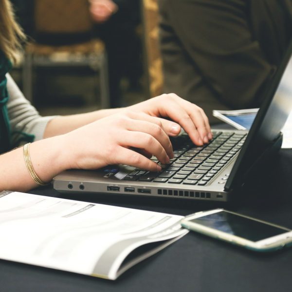 a woman types on a laptop