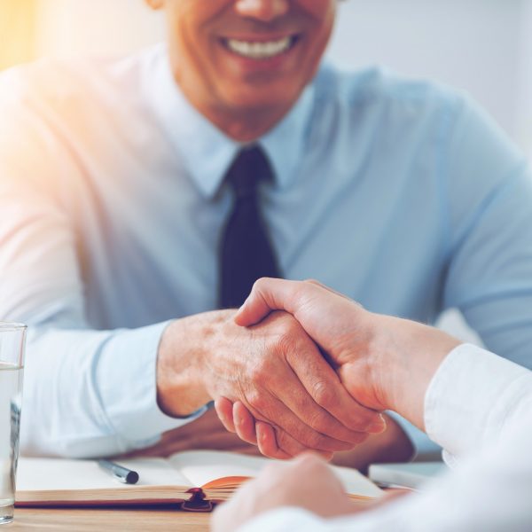 two people shaking hands at the beginning of a job interview