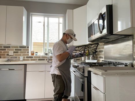 WorkBC Assistive Technology Services participant Eliezar cleaning a stove