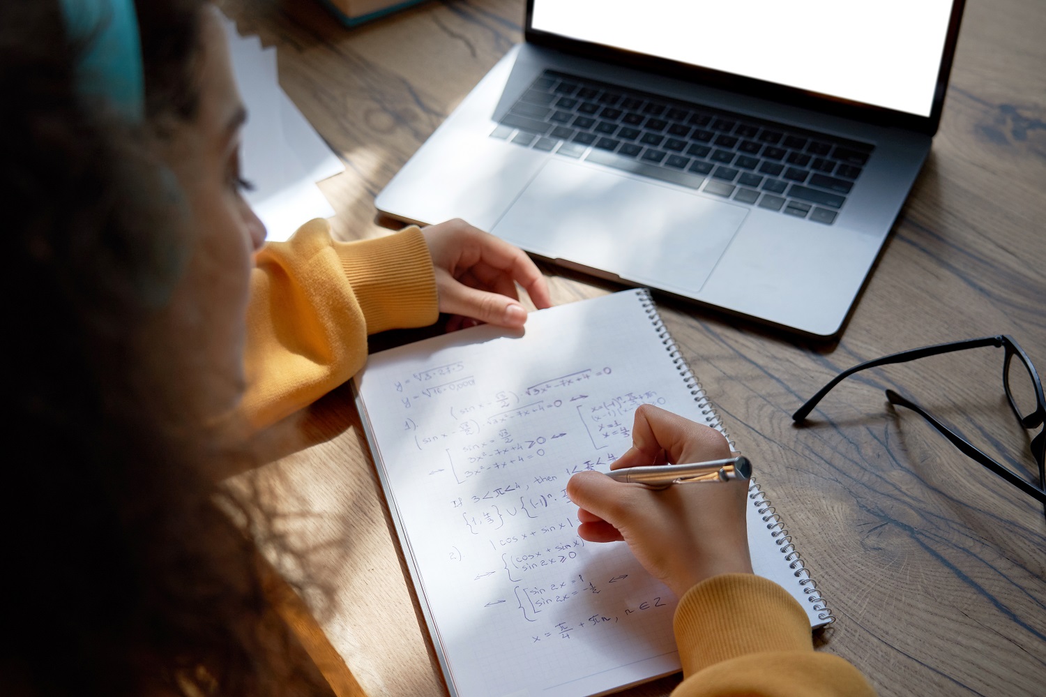 a person writing math equations in a notepad