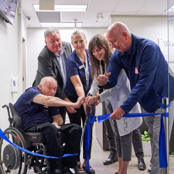 Executive Director Gary Birch, Paul Holden, Hearing Solutions receptionist Cheri, Hearing Solutions audiologist Heather, and Mayor Mike Hurley cut the ribbon