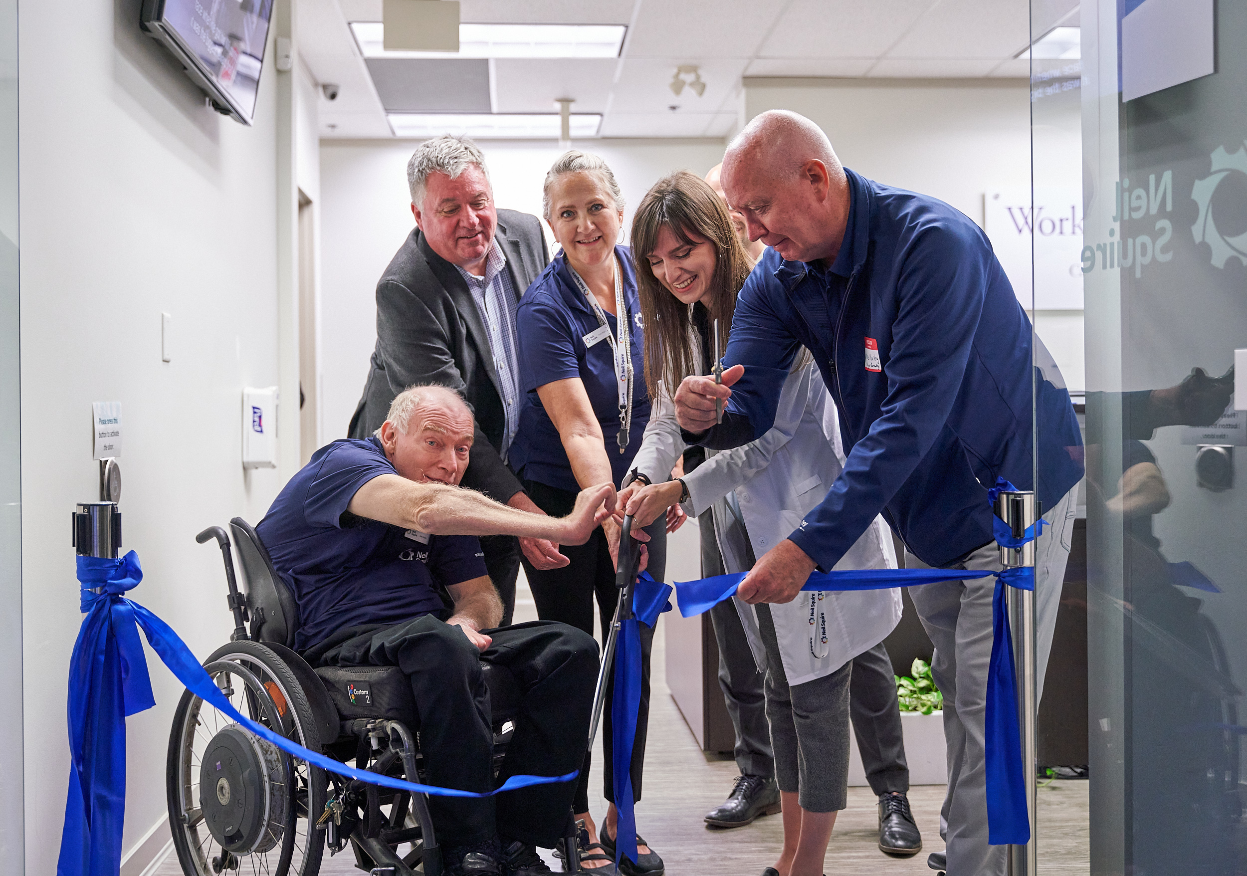 Executive Director Gary Birch, Paul Holden, Hearing Solutions receptionist Cheri, Hearing Solutions audiologist Heather, and Mayor Mike Hurley cut the ribbon
