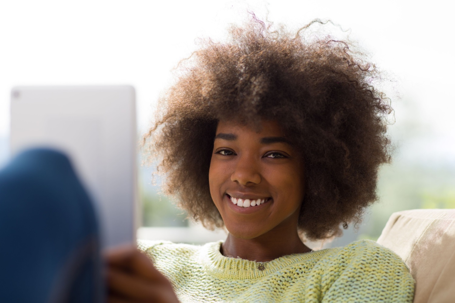 a woman smiling, using a tablet