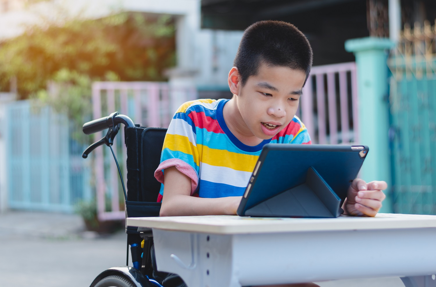 a boy in a wheelchair uses a tablet