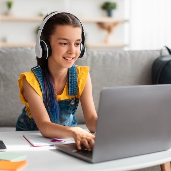 a kid wearing headphones using a laptop