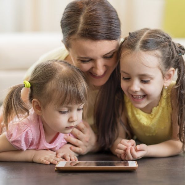 a mom reading a tablet with her children