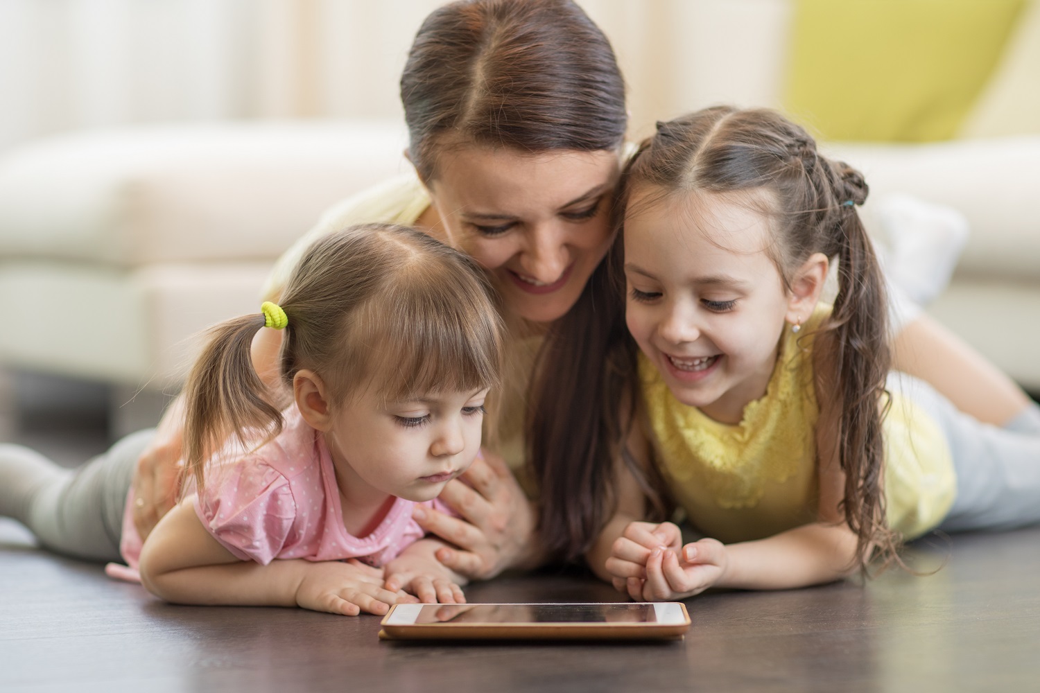 a mom reading a tablet with her children