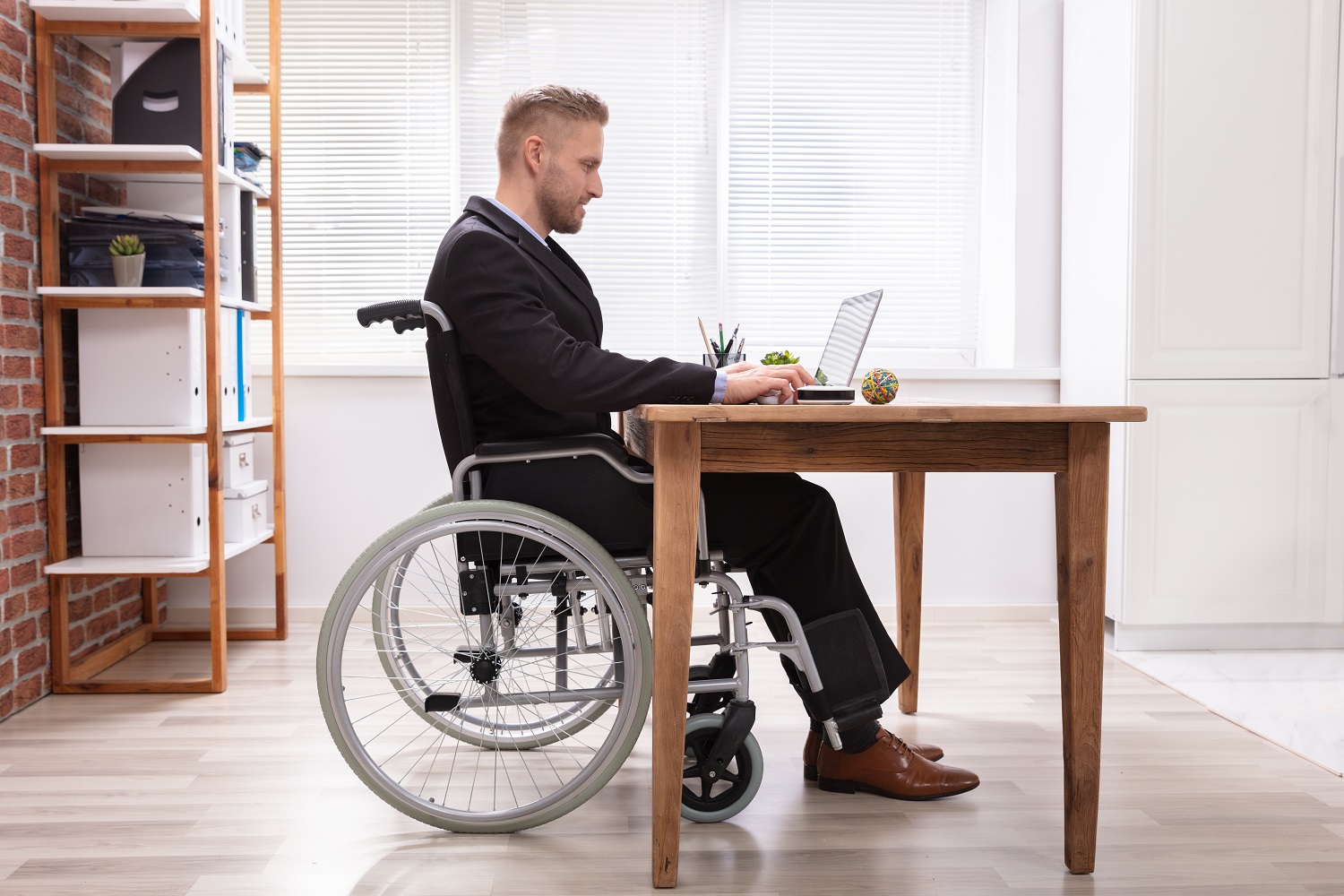 a man in a wheelchair using a laptop