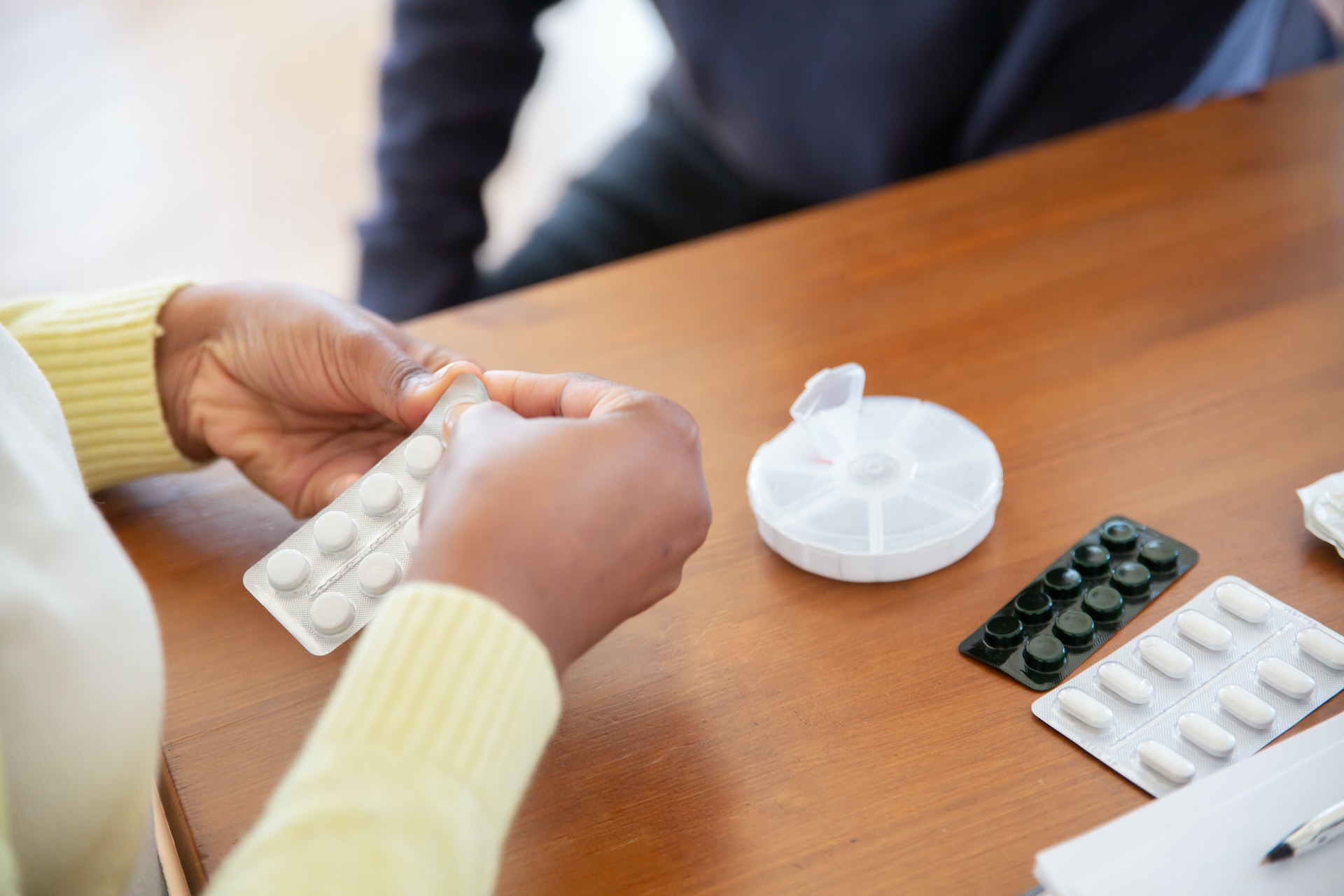 a care aid getting out pills for a senior