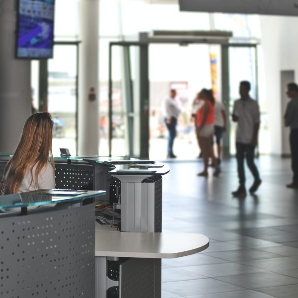 a receptionist sits at the desk in the entrance to a busy building